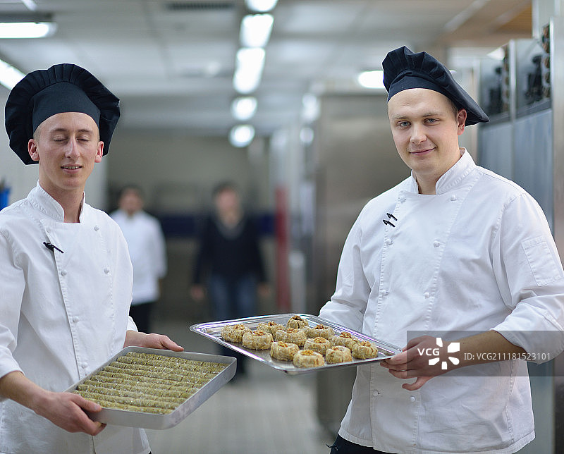 专注的男糕点师在厨房装饰甜点蛋糕 close-up图片素材