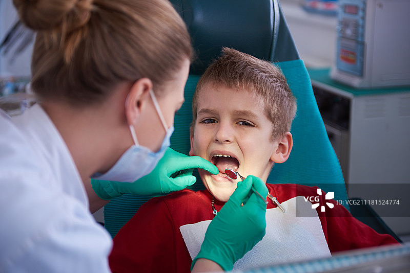 年轻男孩在牙科诊所检查牙齿图片素材
