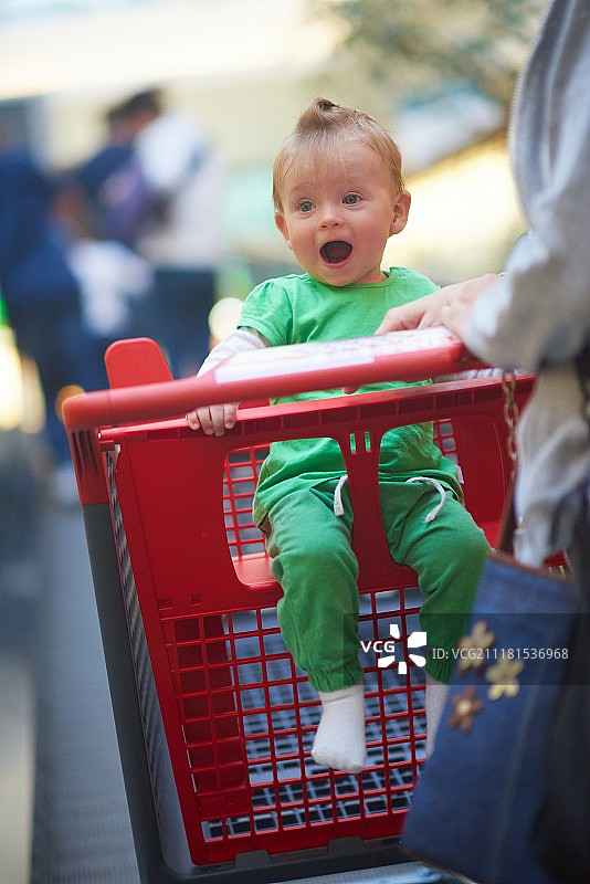 年轻的母亲和婴儿在购物中心超市购买食品和杂货图片素材
