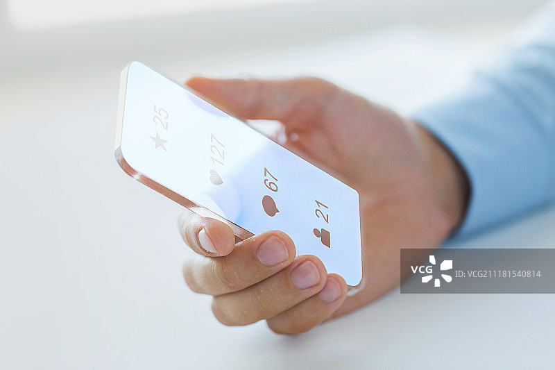 商务、未来技术和人员概念 - 男人手持透明智能手机，在黑色背景上显示社交媒体图标图片素材