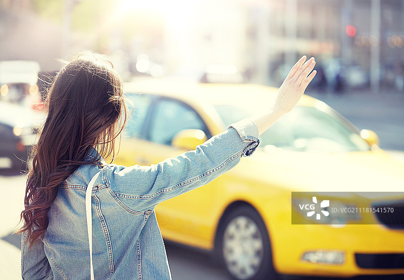 在城市街道上乘坐出租车的年轻女子图片素材