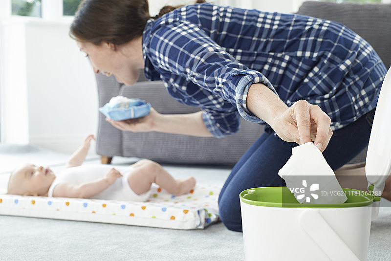 母亲将婴儿湿巾扔进垃圾桶图片素材