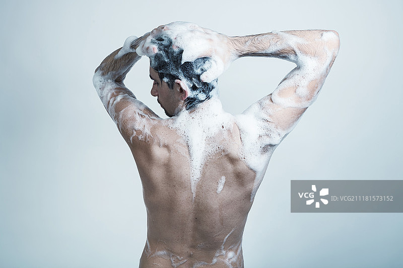 身上沾满肥皂泡的年轻男人图片素材
