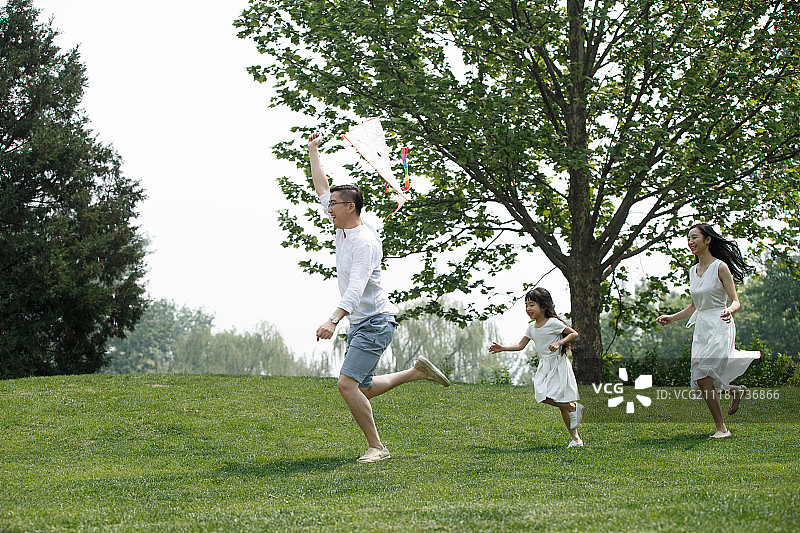 一家三口在草地上放风筝图片素材