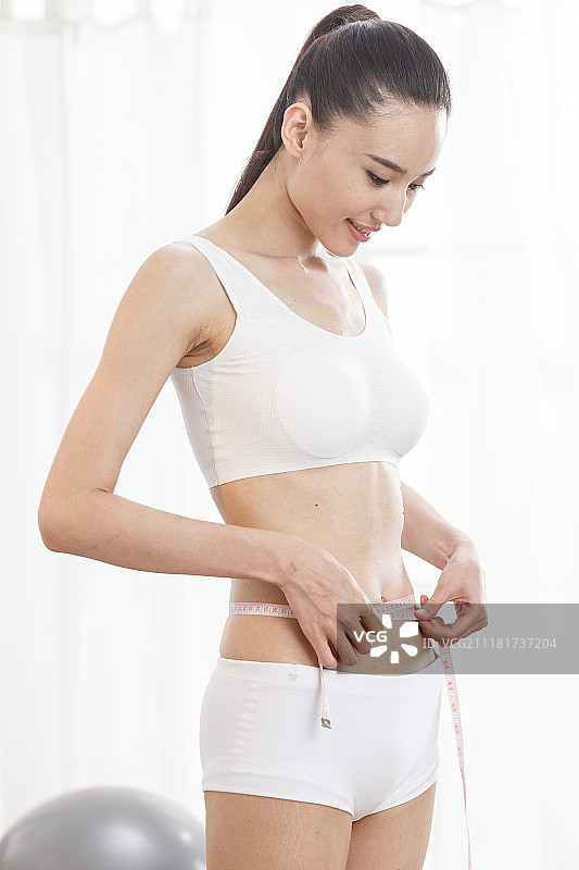 青年女人测量腰围图片素材