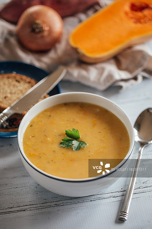 盘中的胡萝卜汤，背景是洋葱和南瓜图片素材