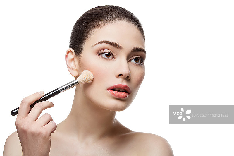 年轻女子用刷子化妆，白色背景图片素材