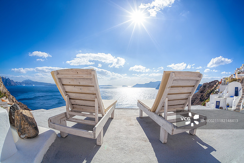 在希腊圣托里尼岛伊亚村的日光浴床上放松身心，欣赏日落图片素材
