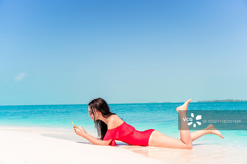 年轻女子戴着帽子在热带海滩上图片素材