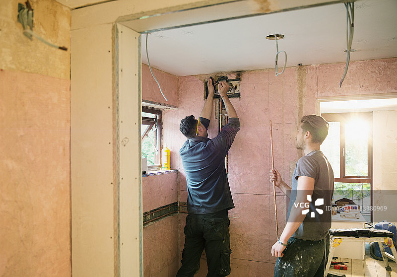 建筑工人在房屋内安装铜管图片素材