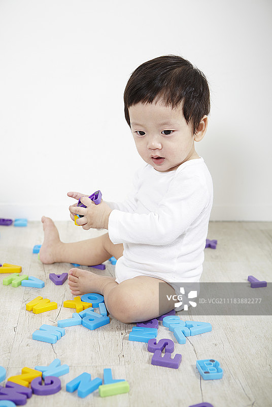 宝宝坐在地板上玩玩具摄影图片素材