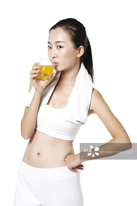 身穿运动服喝橙汁的女人摄影图片素材