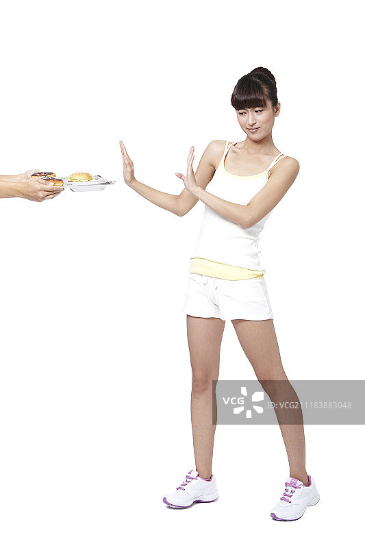 穿运动服躲避甜甜圈和汉堡包的女人照片图片素材