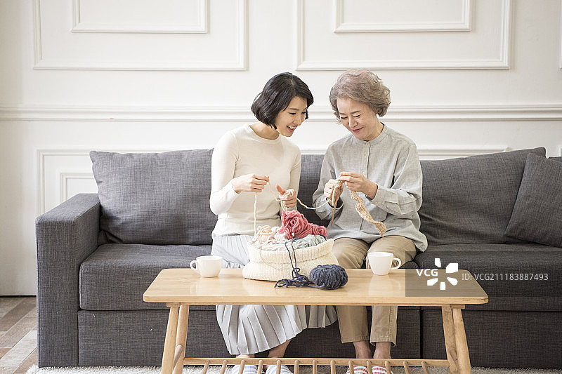 坐在沙发上编织的母女摄影图片素材