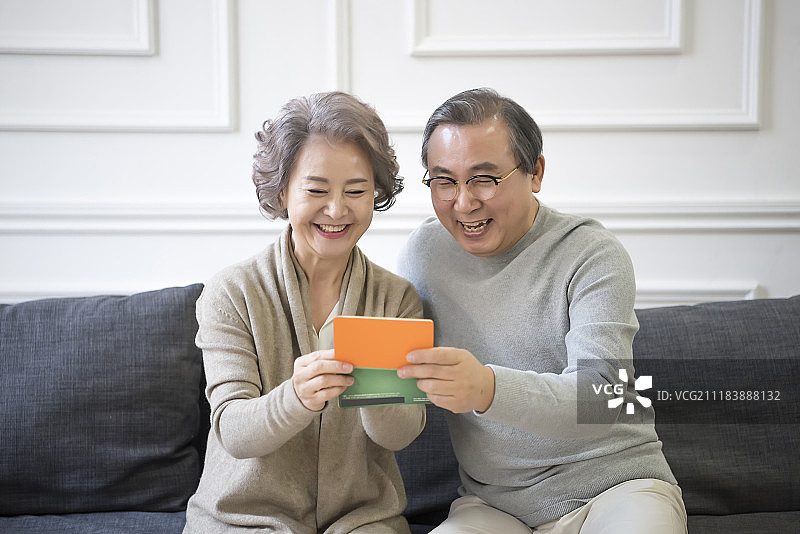 坐在沙发上看存折的老年夫妇摄影图片素材