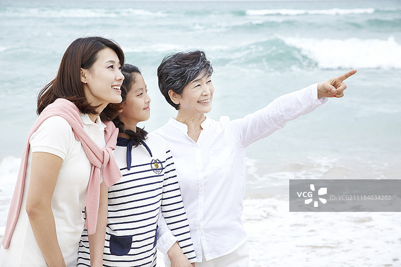 在海滩上的祖母、母亲和女孩的摄影图片素材