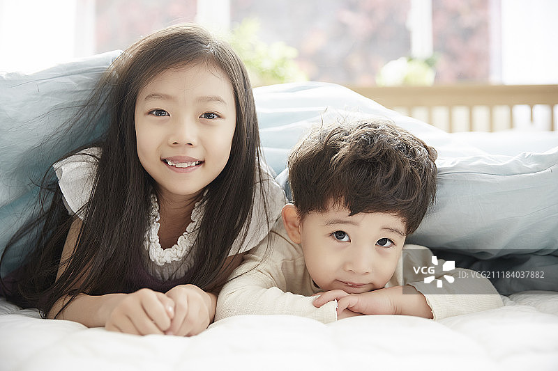 在床上玩耍的小男孩和小女孩摄影图片素材