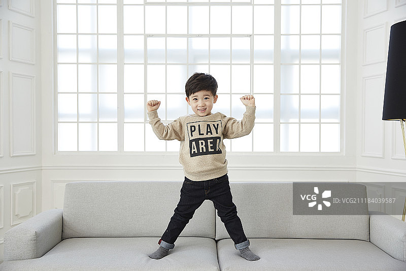 在沙发上玩耍的小男孩摄影图片素材