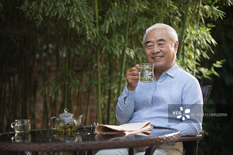 休闲的老年男人坐在院子里图片素材
