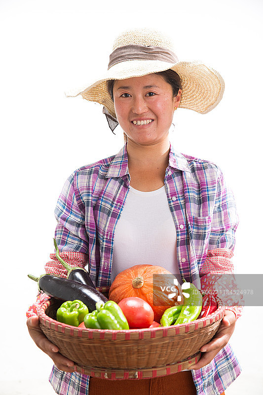 中年女人拿着一筐蔬菜图片素材