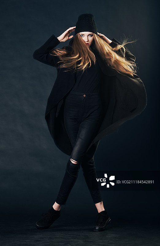 身穿黑色休闲装的年轻女人摆姿势图片素材