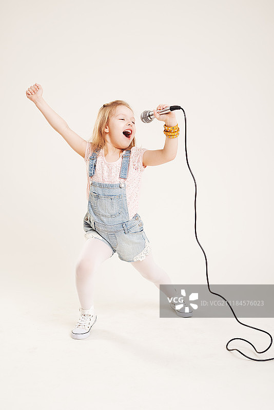 手持麦克风唱歌跳舞的女孩图片素材