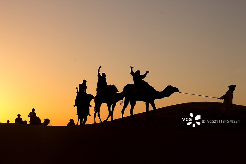 日落时沙漠上的人物剪影图片素材