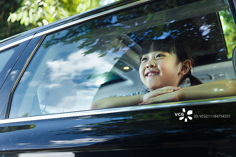 快乐的小女孩坐在车里图片素材