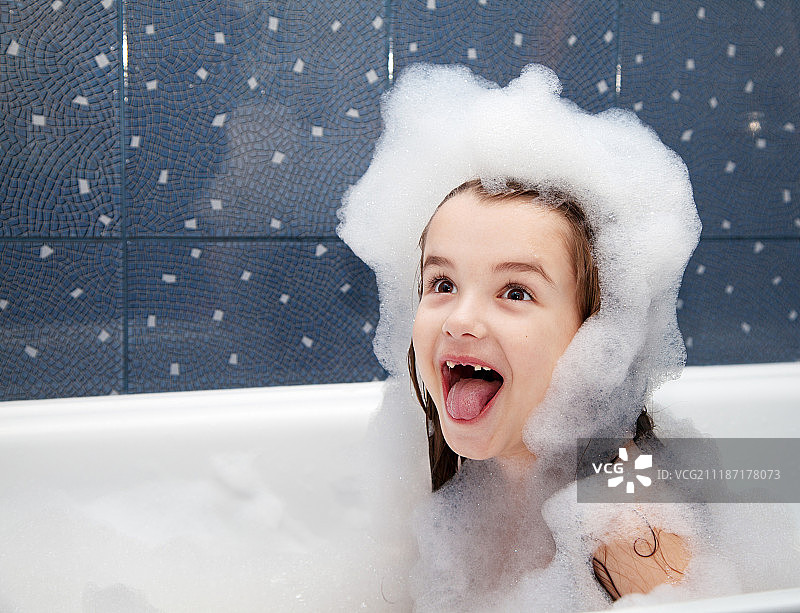坐在浴缸里惊讶的小女孩图片素材