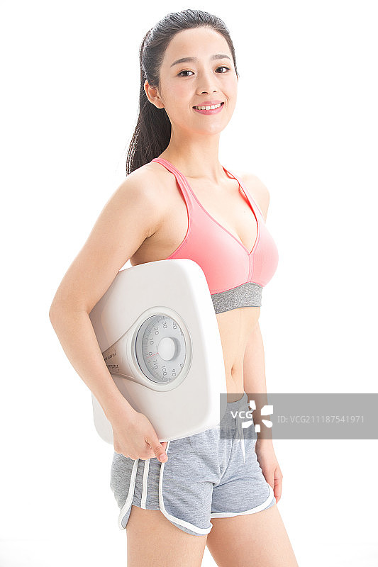 青年女人拿着浴室秤图片素材