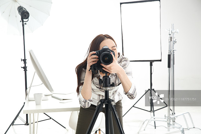 青年女摄影师拿着手机图片素材