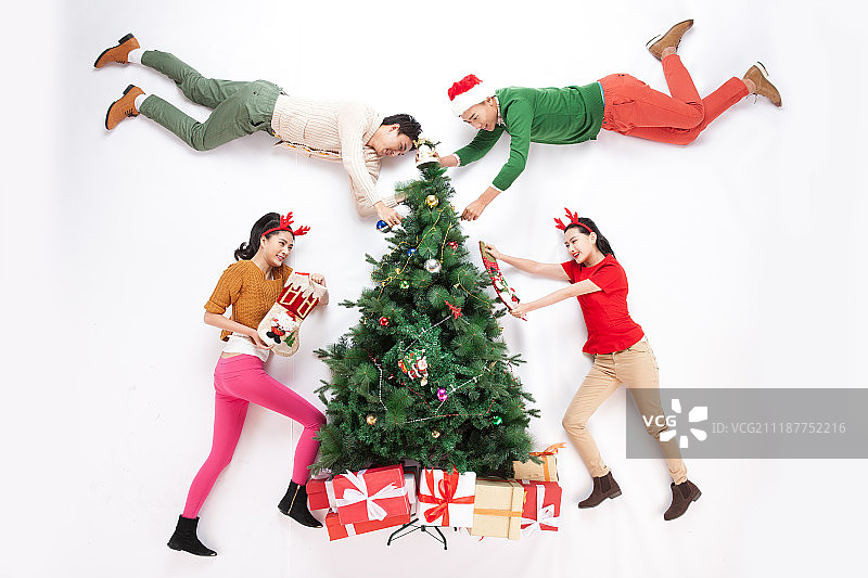 四个青年男女正在装饰圣诞树图片素材