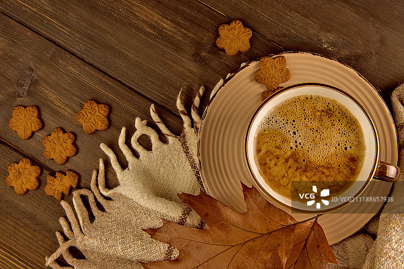木质背景上的咖啡杯、曲奇饼干和格子花纹橡树叶图片素材