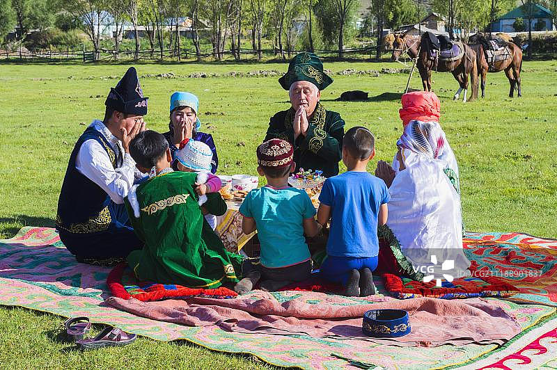 哈萨克族家庭在午餐前祈祷，位于哈萨克斯坦天山山脉的萨提村，亚洲图片素材