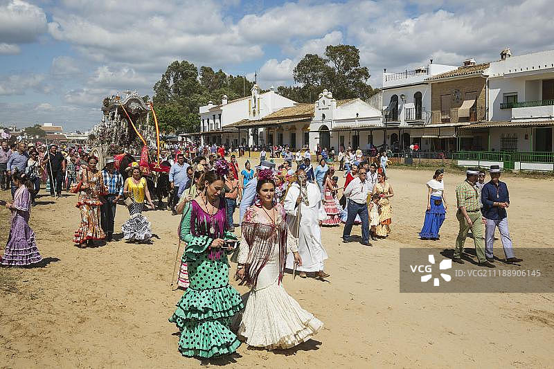 西班牙安达卢西亚埃尔罗西奥朝圣活动中身着传统服饰、乘坐装饰牛车的人们图片素材