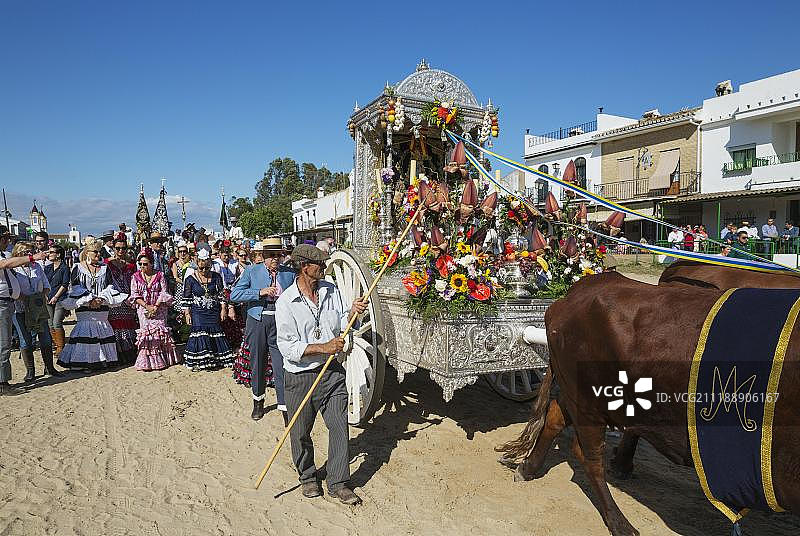 西班牙安达卢西亚埃尔罗西奥朝圣活动中身着传统服饰、乘坐装饰牛车的人们图片素材