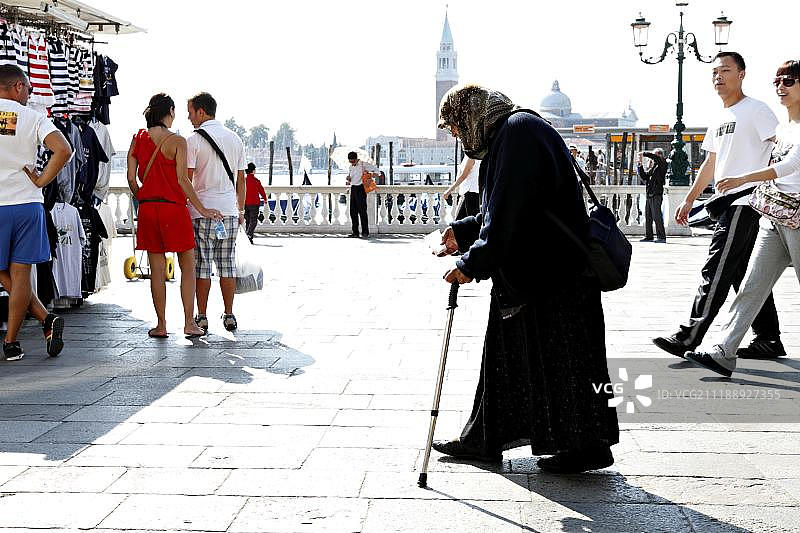 行走在游客中的乞讨女人，威尼斯，意大利，欧洲图片素材