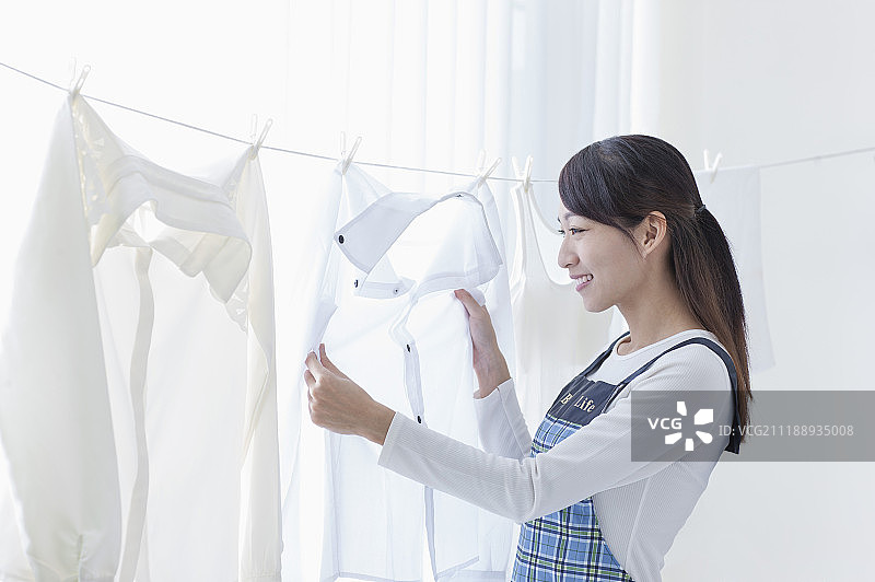 年轻女人在晒衣服图片素材