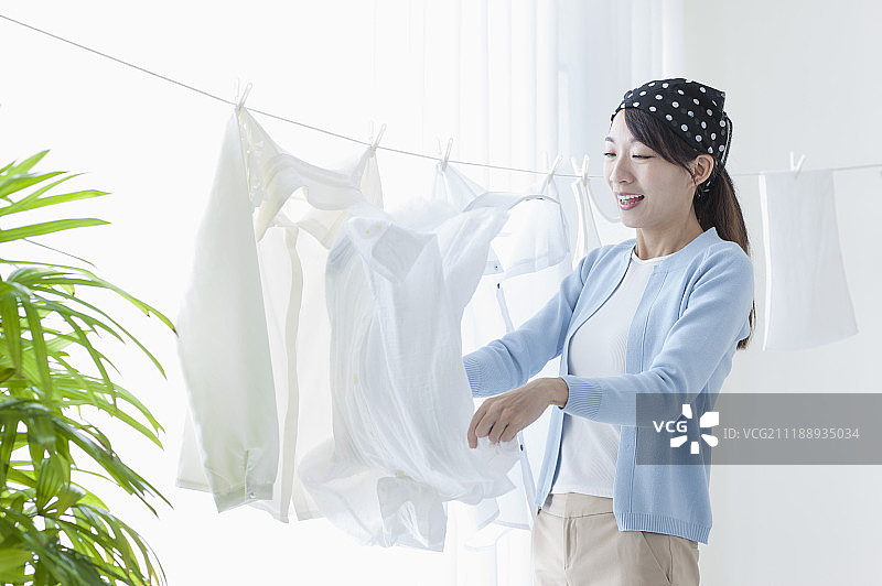 年轻女人在晒衣服图片素材
