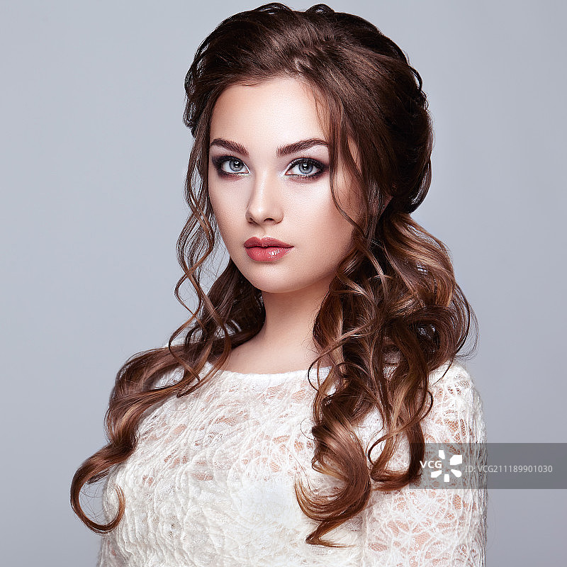 拥有长而有光泽的卷发的棕发女人图片素材