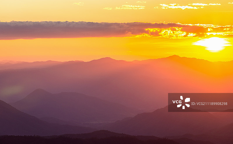 朦胧的山脉与壮丽的日落天空图片素材