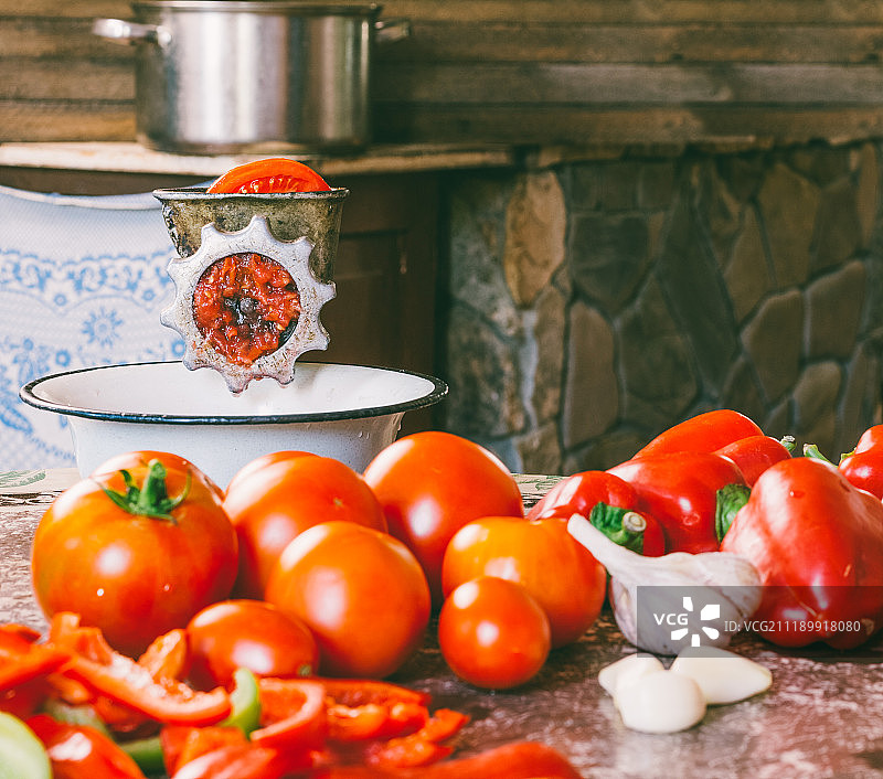 老式复古手动研磨机与新鲜番茄、红椒和大蒜图片素材