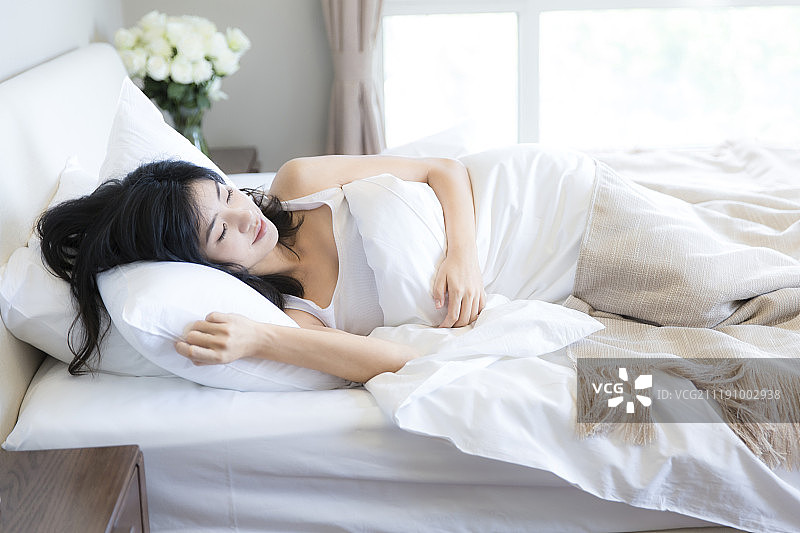 年轻女孩在卧室床上睡觉图片素材