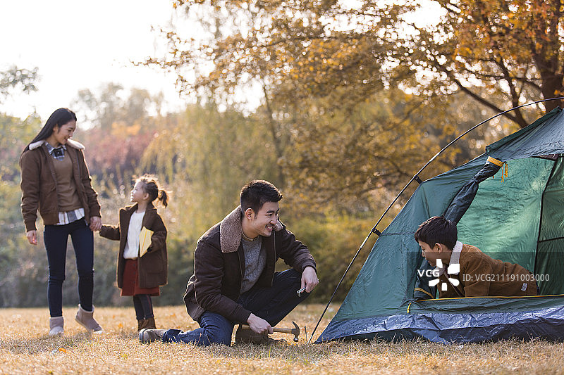 一家四口户外郊游搭帐篷图片素材