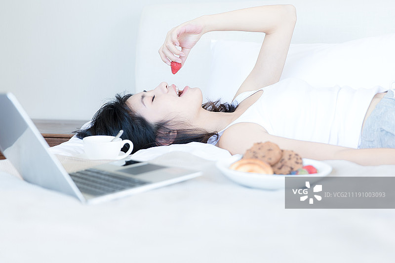 年轻女子在卧室床上休息图片素材