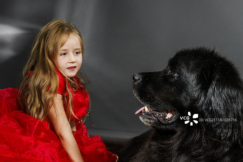 美女与抱着黑色水犬的女孩图片素材