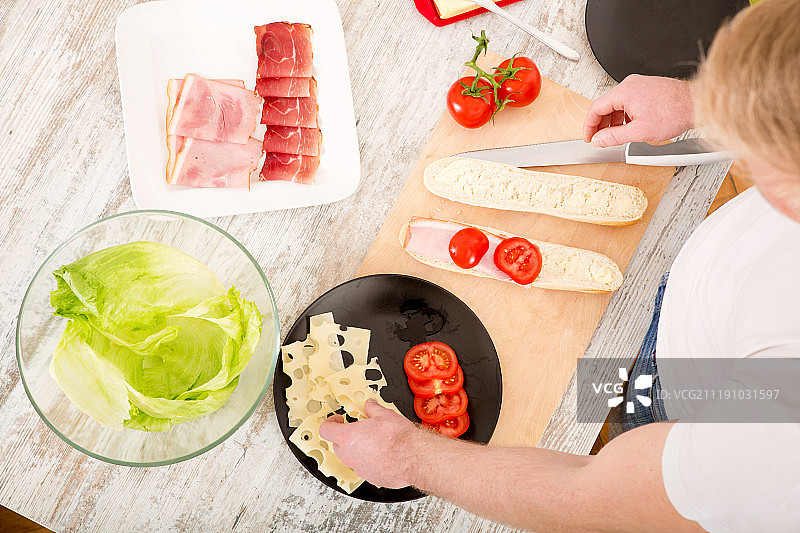 年轻男子准备三明治图片素材