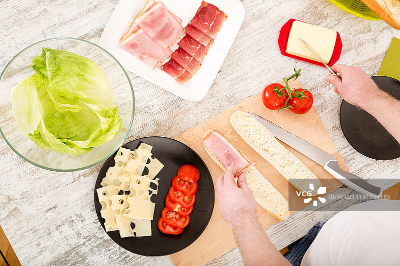 年轻男子准备三明治图片素材