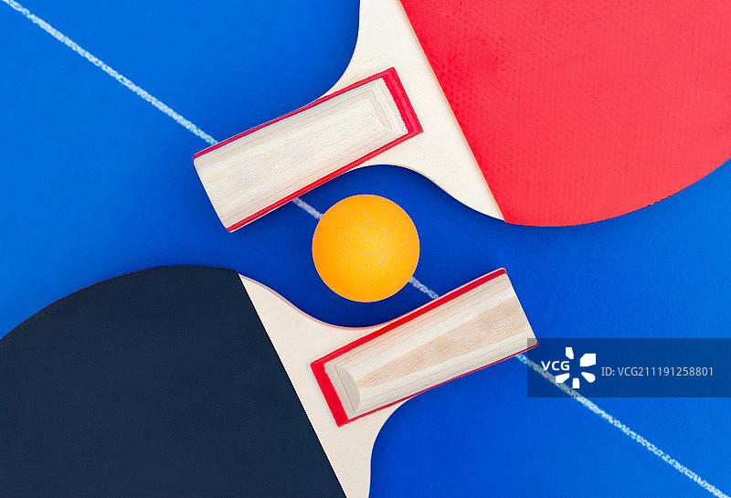 摆放于球台中线上的一对乒乓球拍和乒乓球图片素材