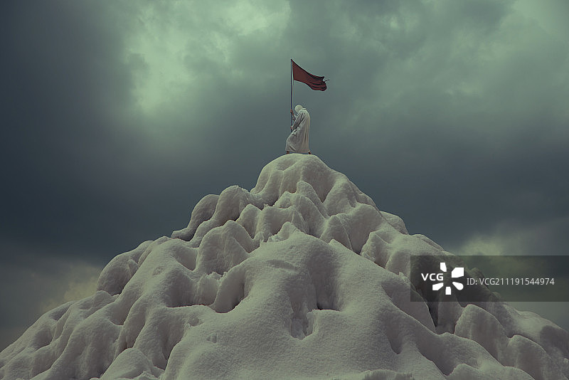 站在雪山顶上举着旗子的人图片素材